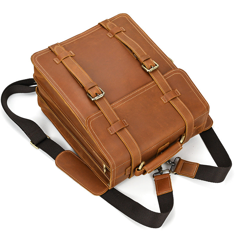 Brown leather briefcase with black strap on a white background