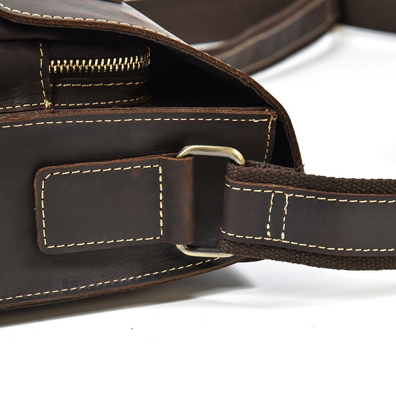 Close-up of a brown leather bag with a strap on a white background
