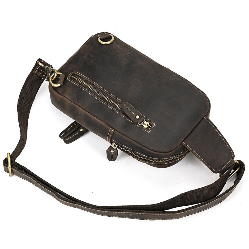 Brown leather sling bag with a strap on a white background