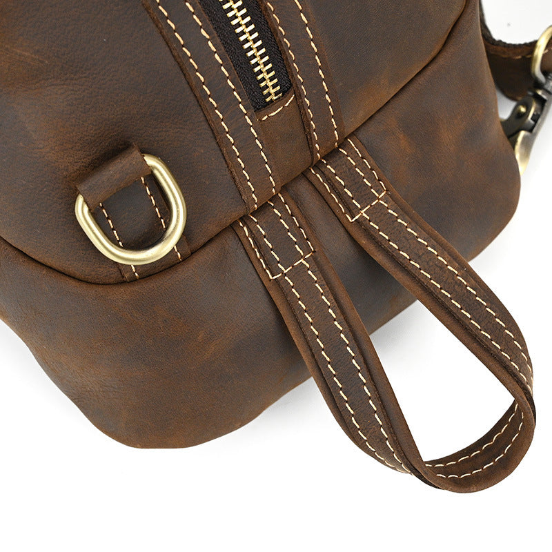 Close-up of the brass D-ring hardware and bottom handle loop on the Timber Carry Crazy Horse Leather Sling Bag.