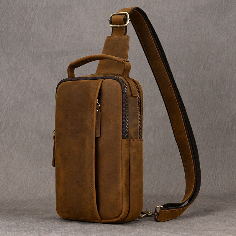 Brown leather sling bag on a gray background
