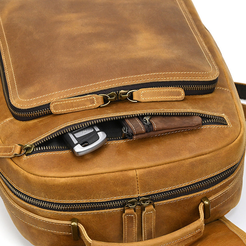 Close-up of a brown leather suitcase with zippers on a white background