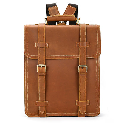 Brown leather backpack with gold buckles on a white background