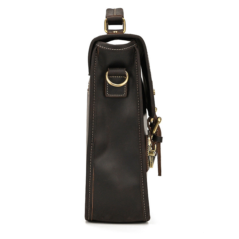Dark brown leather wine bottle holder with gold accents on a white background