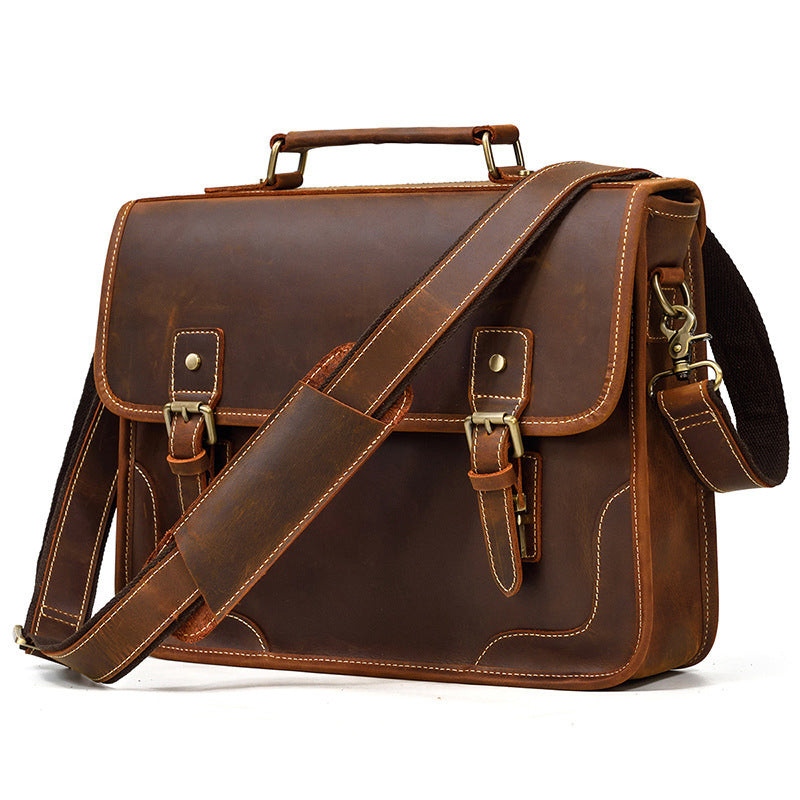 Angled view of the Brown leather briefcase with a matching shoulder strap, suitable for business travel.