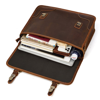 Opened Brown leather business bag packed with a laptop, notebooks, and personal items, demonstrating capacity.