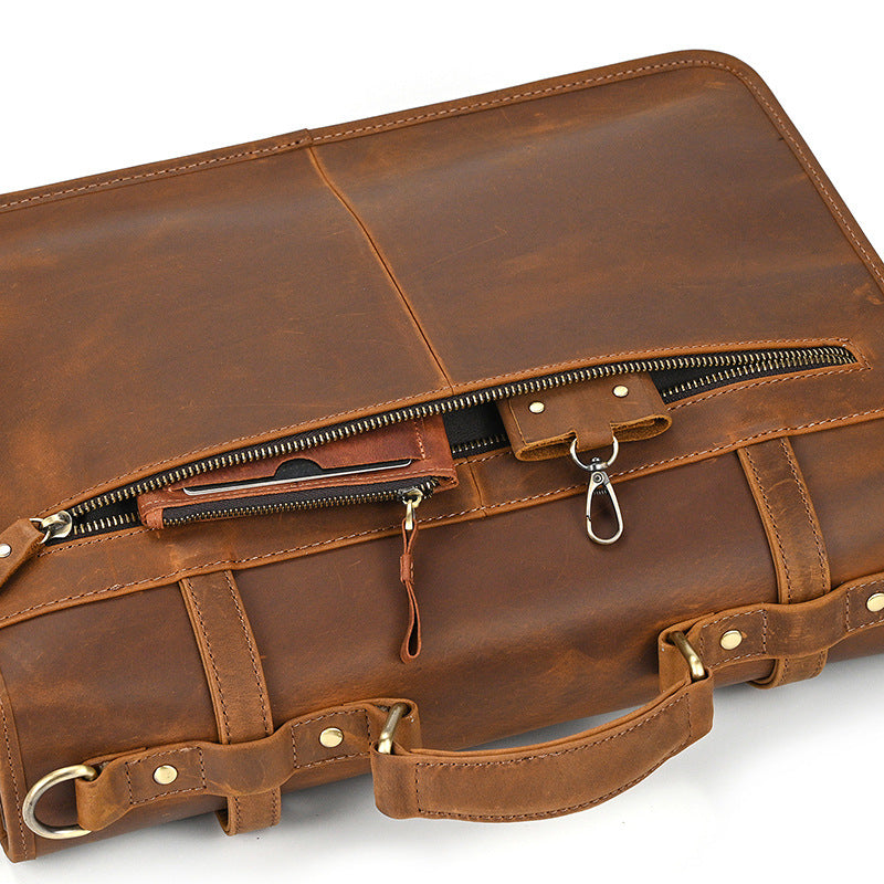 Close-up of back pocket details: key hook and card holder in light brown leather bag.