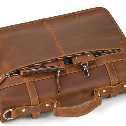 Close-up of back pocket details: key hook and card holder in light brown leather bag.