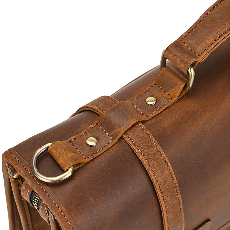 Top view of light brown leather briefcase showing three main zippered compartments and sturdy handle.