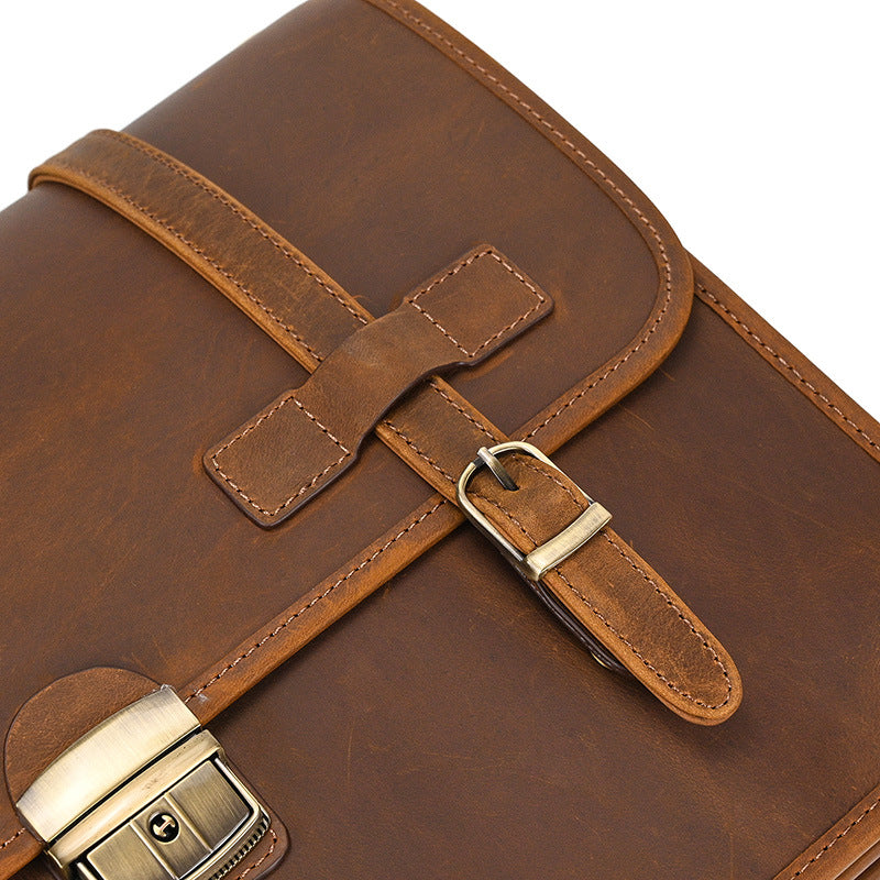 High-quality antique brass clasp hardware on light brown Crazy Horse leather messenger bag.