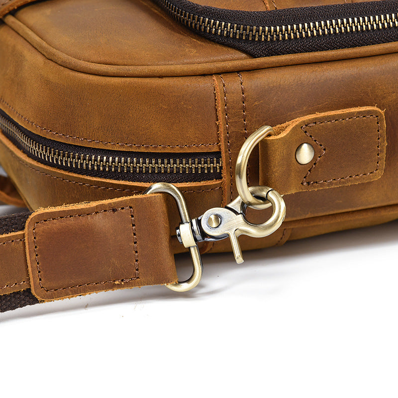 Detailed shot of the high-quality antique brass swivel hook and leather strap attachment on the Light Brown bag.
