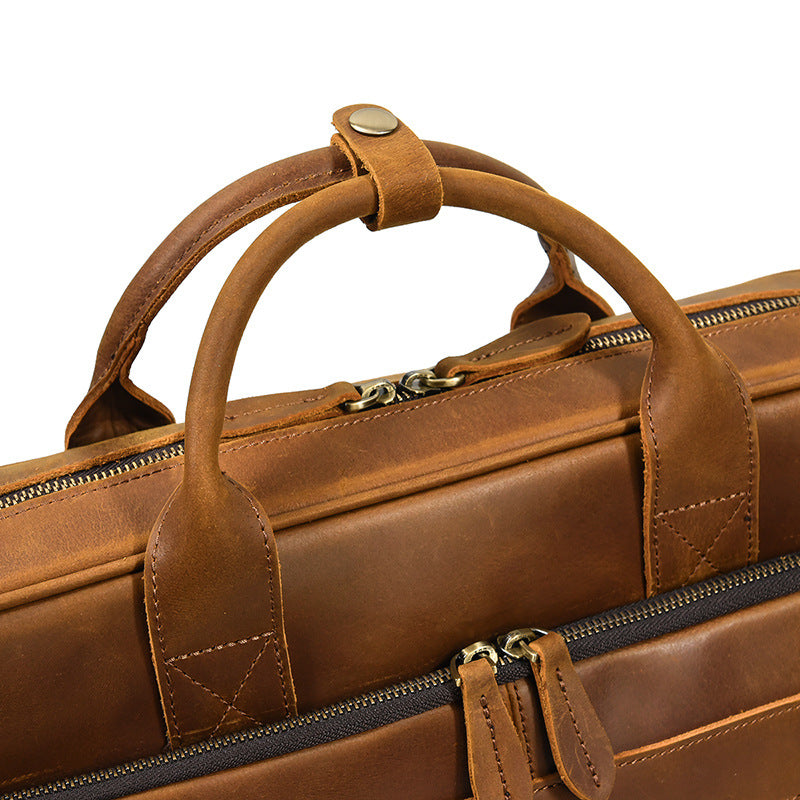 Close-up of the reinforced Light Brown leather top handles and dual-way metal zippers.