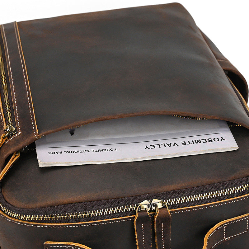 Vintage Brown leather bag with a visible brand name, open to reveal a paper inside.