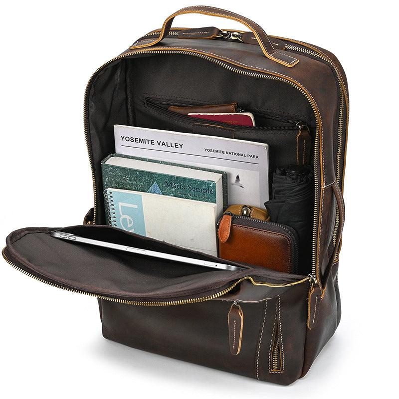 Vintage Brown leather backpack with interior compartments and items on a white background