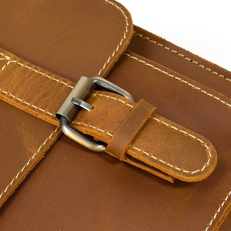 Close-up of a brown leather bag with a buckle on a white background
