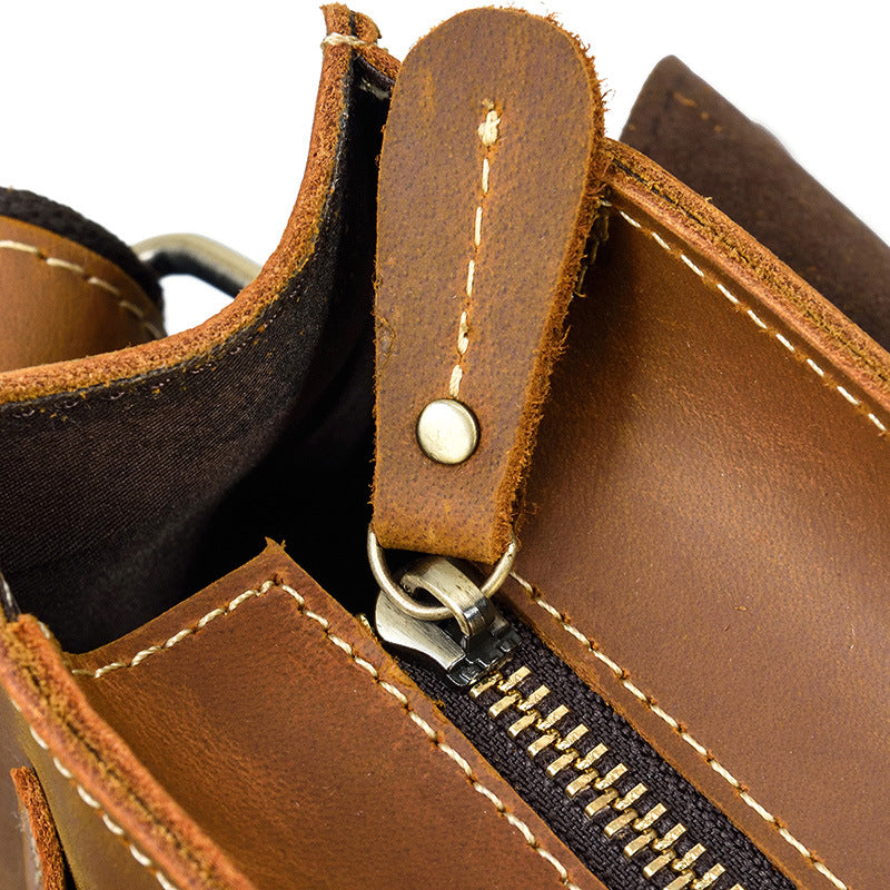 Close-up of a brown leather bag with zipper and stitching details.