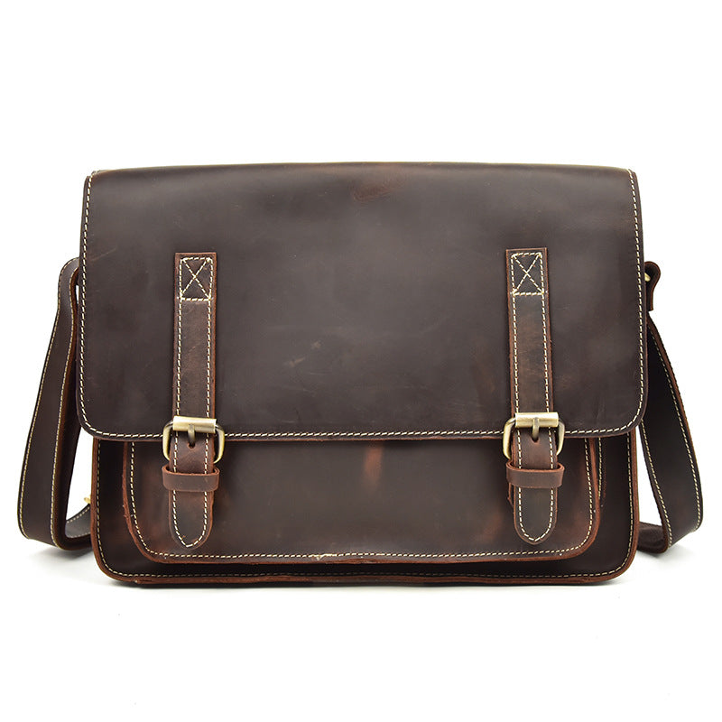 Brown leather satchel bag with gold buckles on a white background