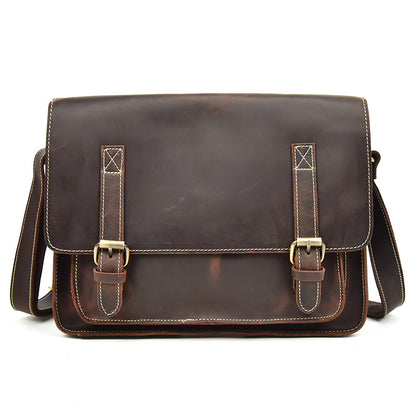Brown leather satchel bag with gold buckles on a white background