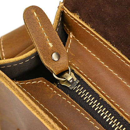Close-up of a brown leather wallet with a zipper and strap.