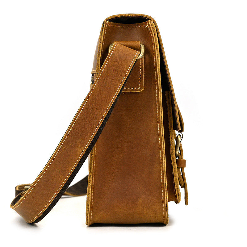 Brown leather bag with a strap on a white background
