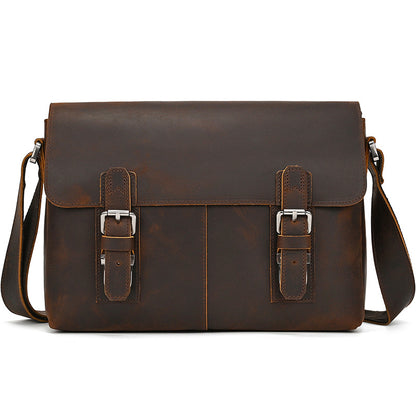 Brown leather satchel bag with silver buckles on a white background