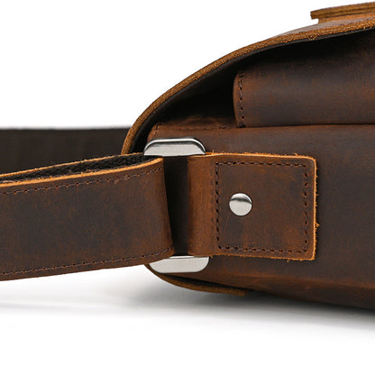 Close-up of a brown leather bag with a strap on a white background