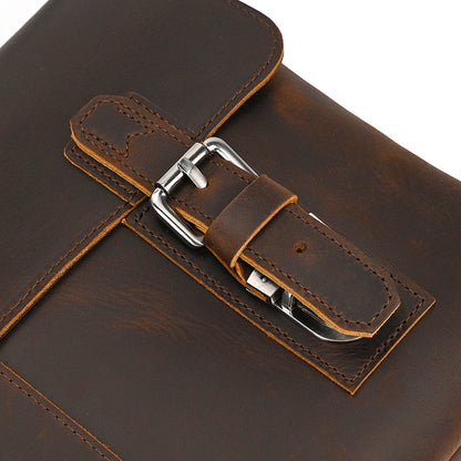Close-up of a brown leather briefcase with a silver buckle on a white background
