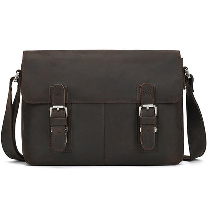 Brown leather satchel bag with silver buckles on a white background