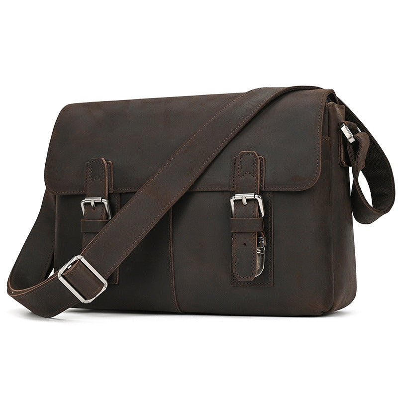 Brown leather satchel bag with silver buckles on a white background