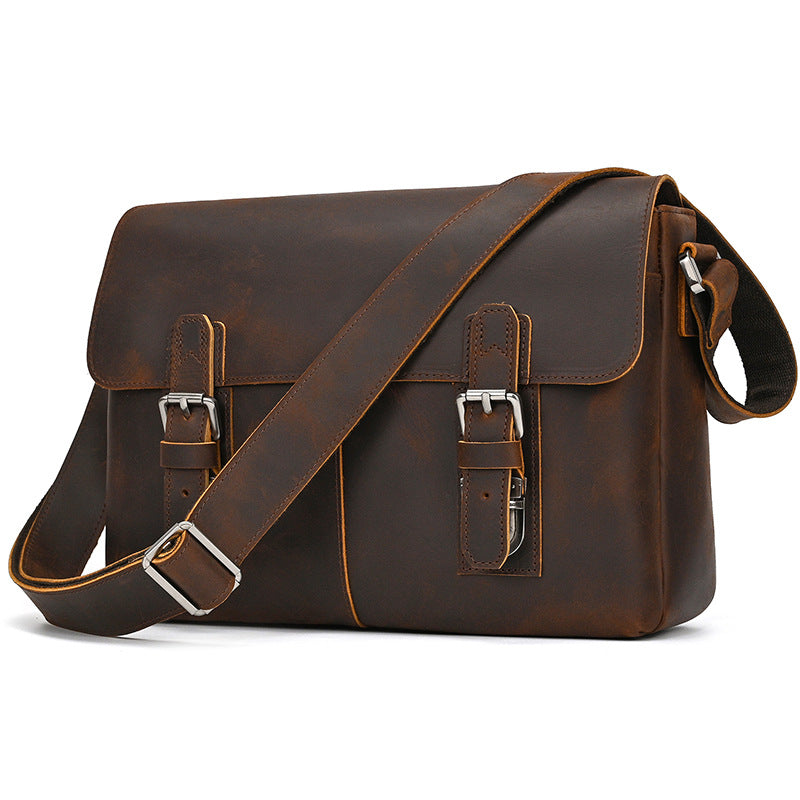 Brown leather satchel bag with silver buckles on a white background