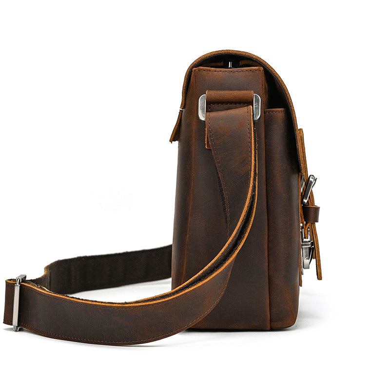 Brown leather bag with a strap on a white background