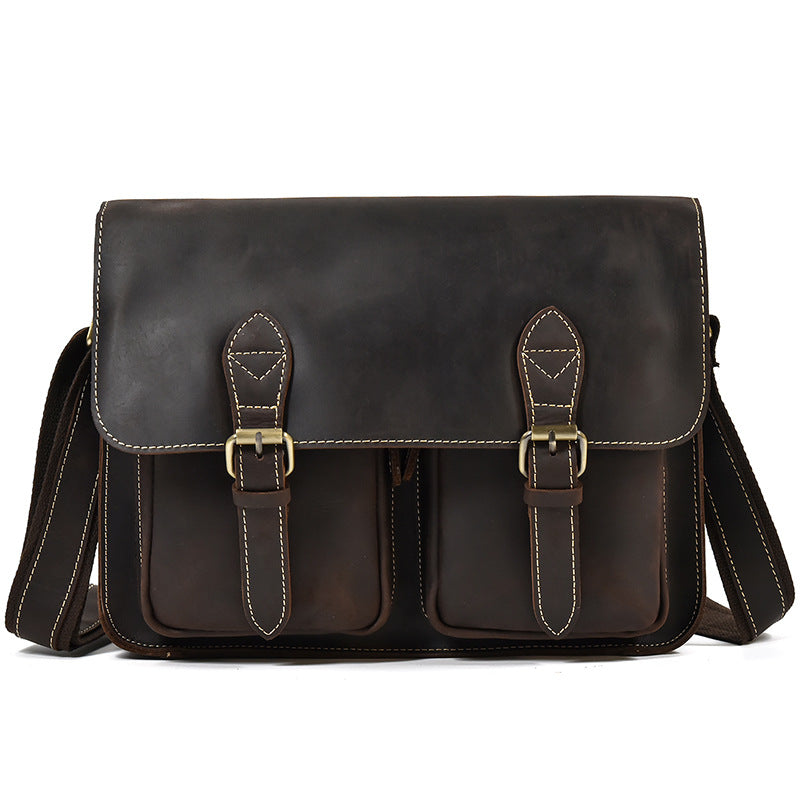 Brown leather satchel bag with gold buckles on a white background