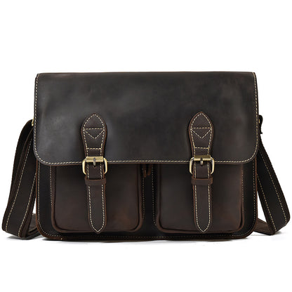 Brown leather satchel bag with gold buckles on a white background