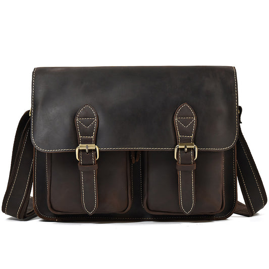 Brown leather satchel bag with gold buckles on a white background