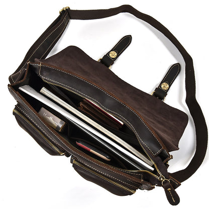 Brown leather bag with a shoulder strap, open to reveal a laptop inside, on a white background.