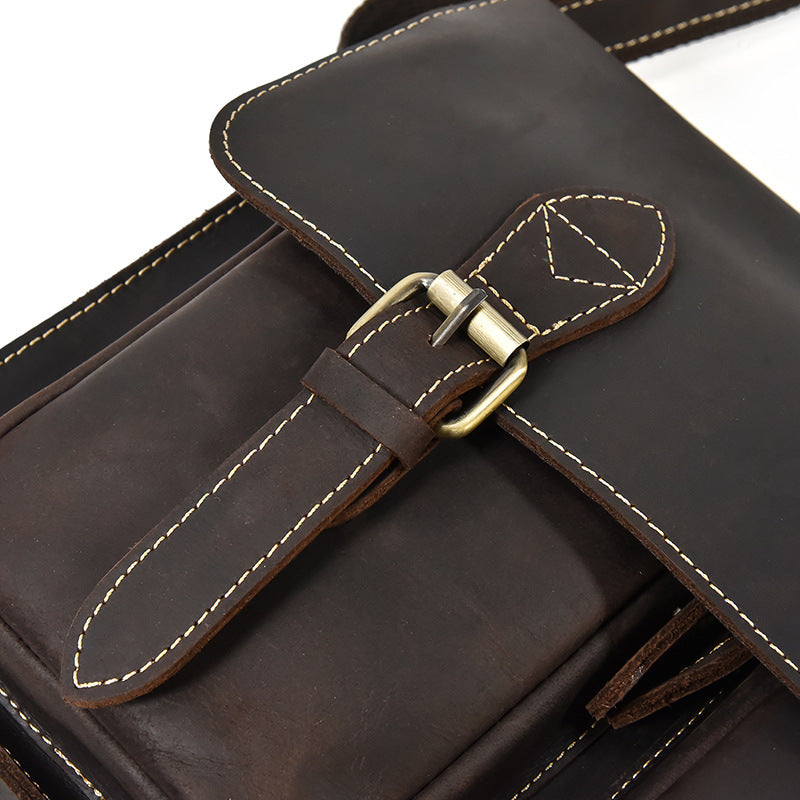 Close-up of a brown leather bag with a buckle on a white background