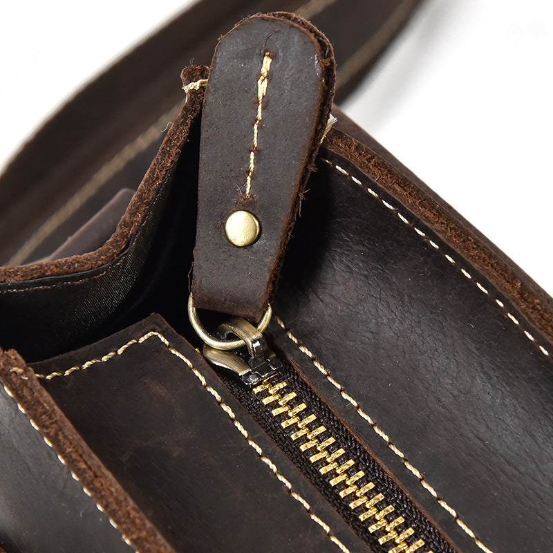 Close-up of a brown leather bag with gold zipper and stitching detail.