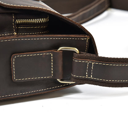 Close-up of a brown leather bag with a strap on a white background