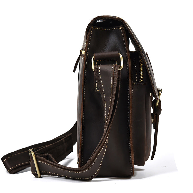 Brown leather satchel bag with gold accents on a white background