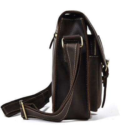 Brown leather satchel bag with gold accents on a white background