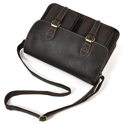 Brown leather handbag with gold buckles on a white background
