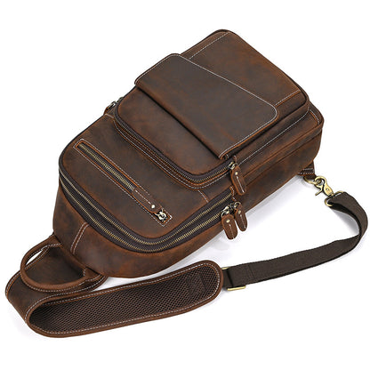 Brown leather satchel bag with multiple zippers on a white background