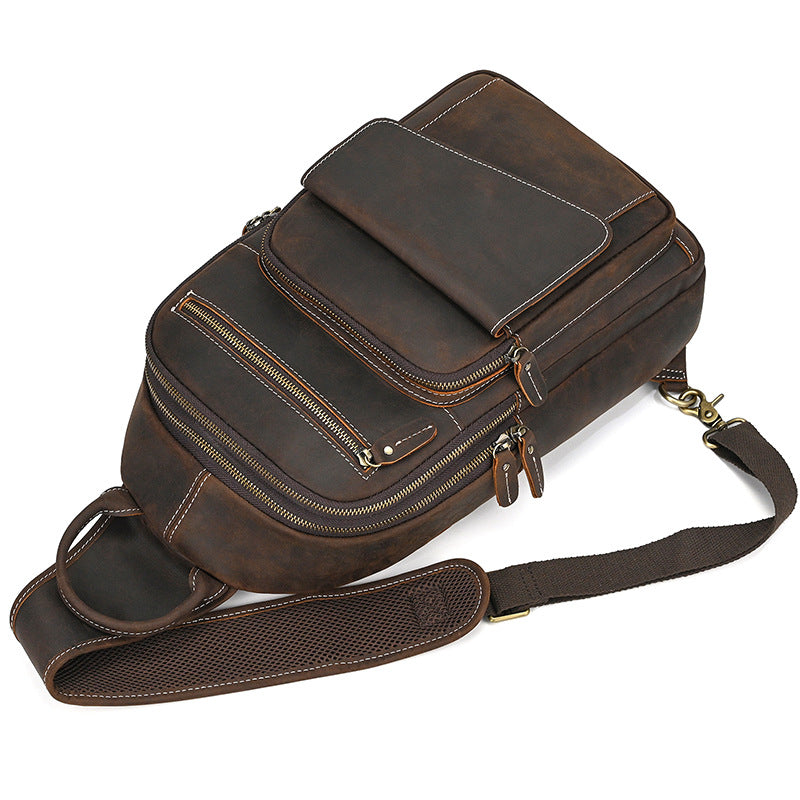 Brown leather backpack with multiple zippers on a white background