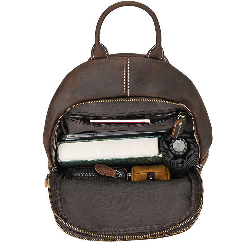 Brown leather backpack with items inside on a white background