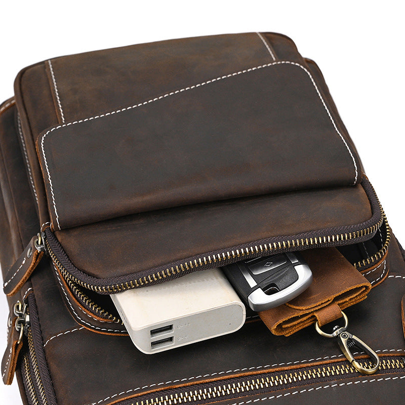 Brown leather bag with electronic devices inside on a white background