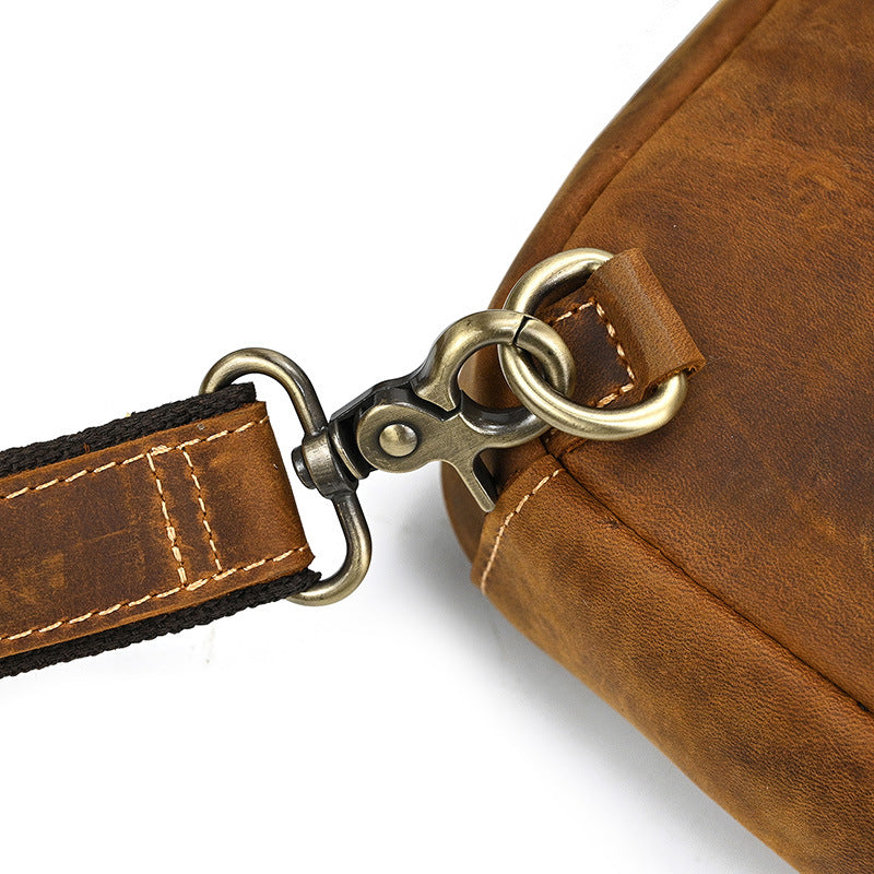 Brown leather bag with strap and clasp on a white background