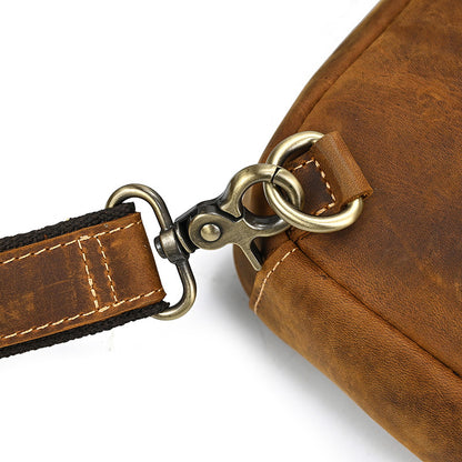 Brown leather bag with strap and clasp on a white background