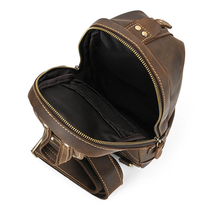 Interior view of the open main compartment of the Crazy Horse Leather Sling Bag, showing the dark lining and an inner pocket.