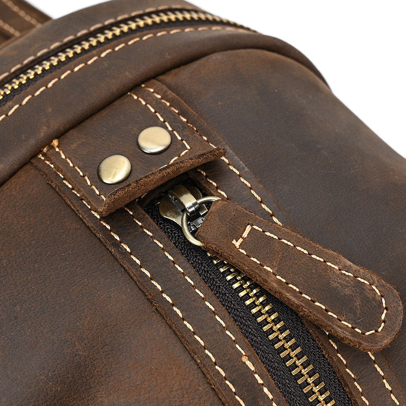 Close-up detail of the durable metal zipper and leather pull on the Timber Carry Crazy Horse Leather Sling Bag.