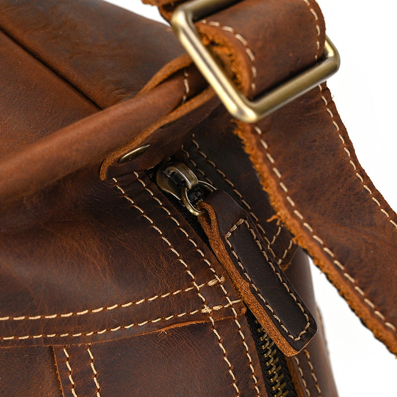 Close-up of the vintage brass zipper pull on Timber Carry Crazy Horse Leather Sling Bag, showing rugged stitching.